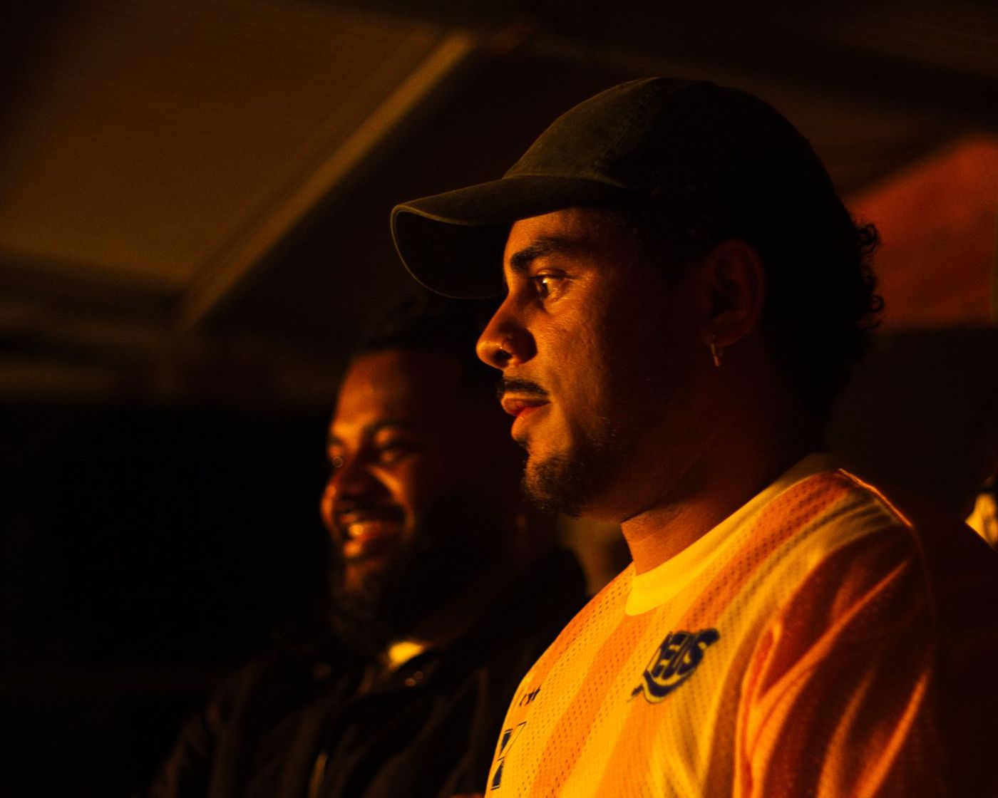 Two men in a warm orange-lit tent
