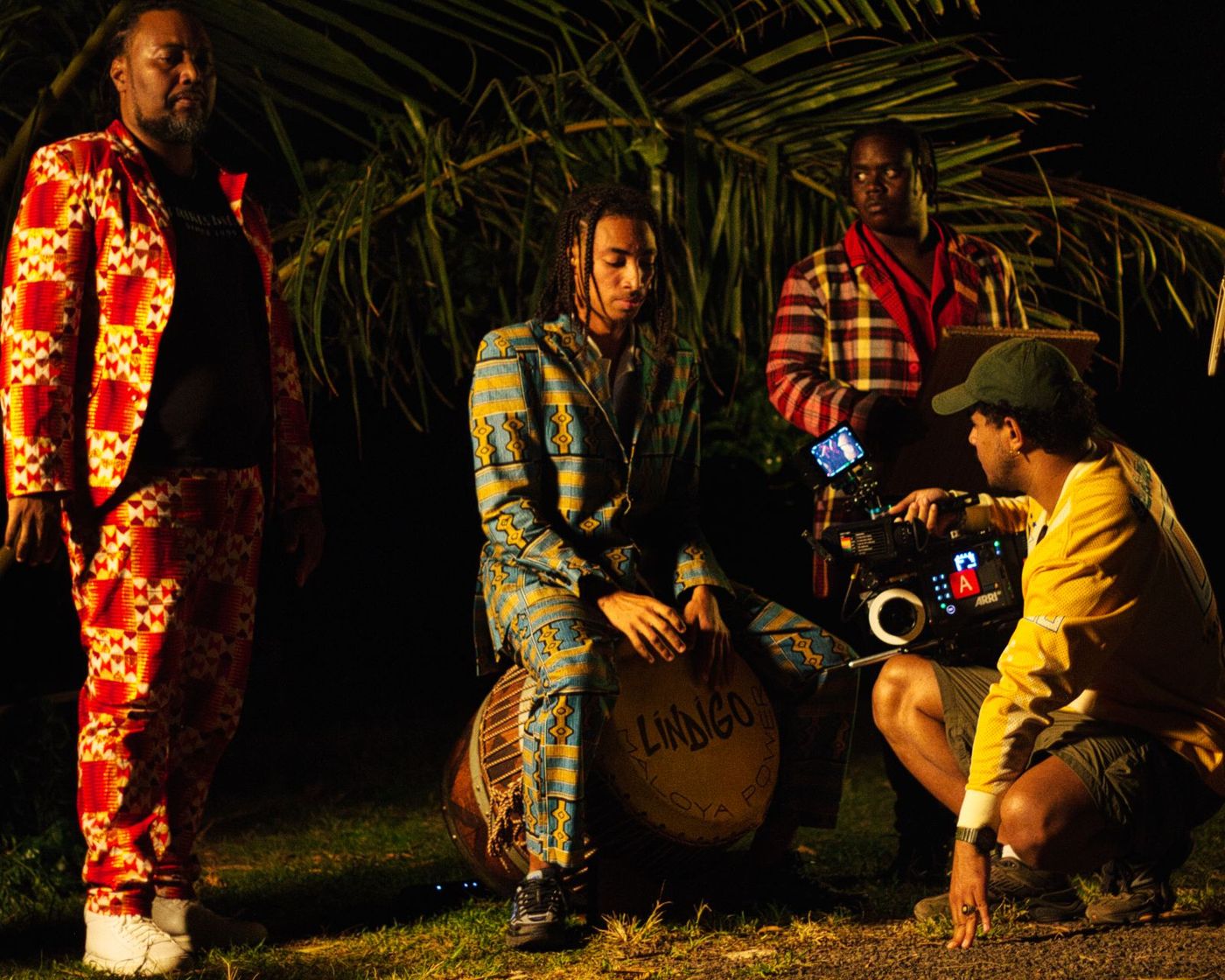 Musicians and camera crew around a drum in the dark