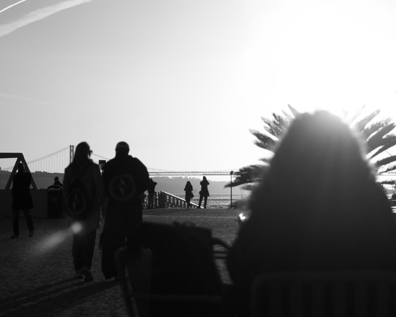 Walkers by the river in bright backlight