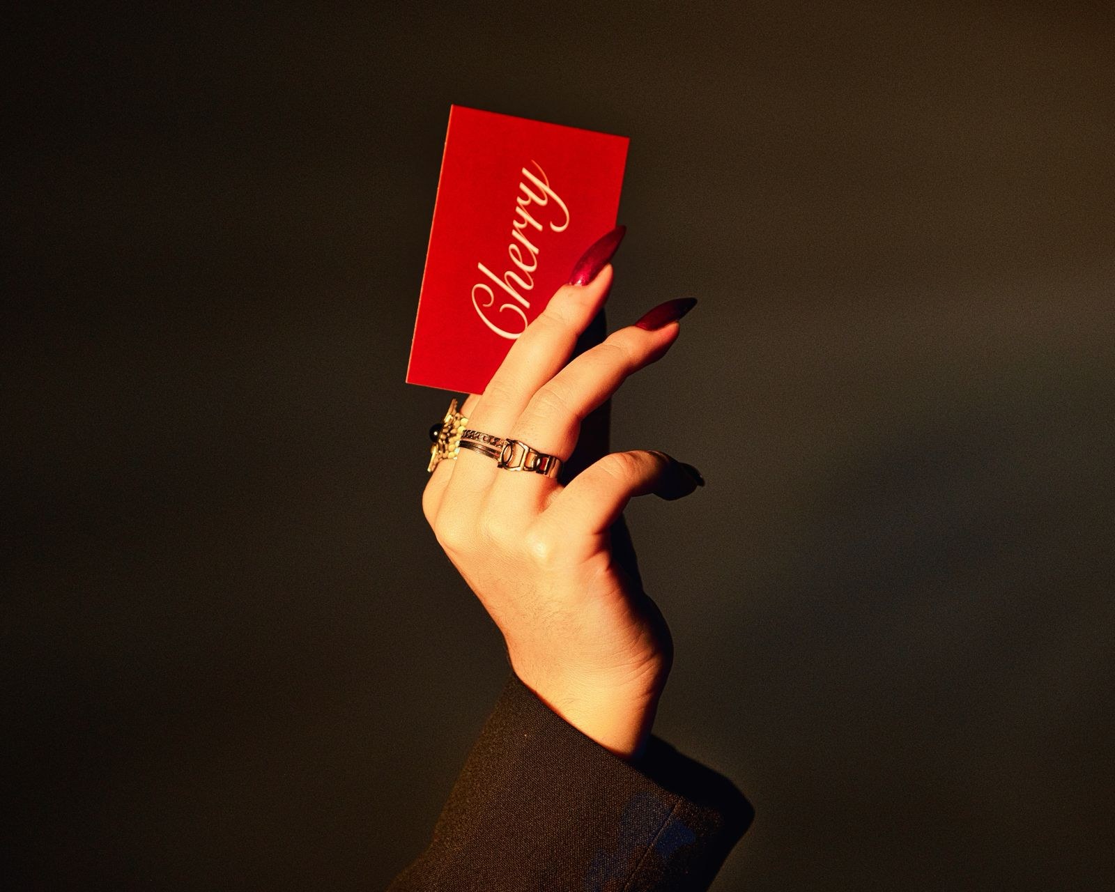 Hand holding a red card in warm side light
