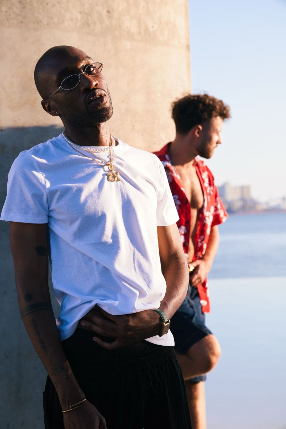 Two men in a white tee and a red shirt at sunset